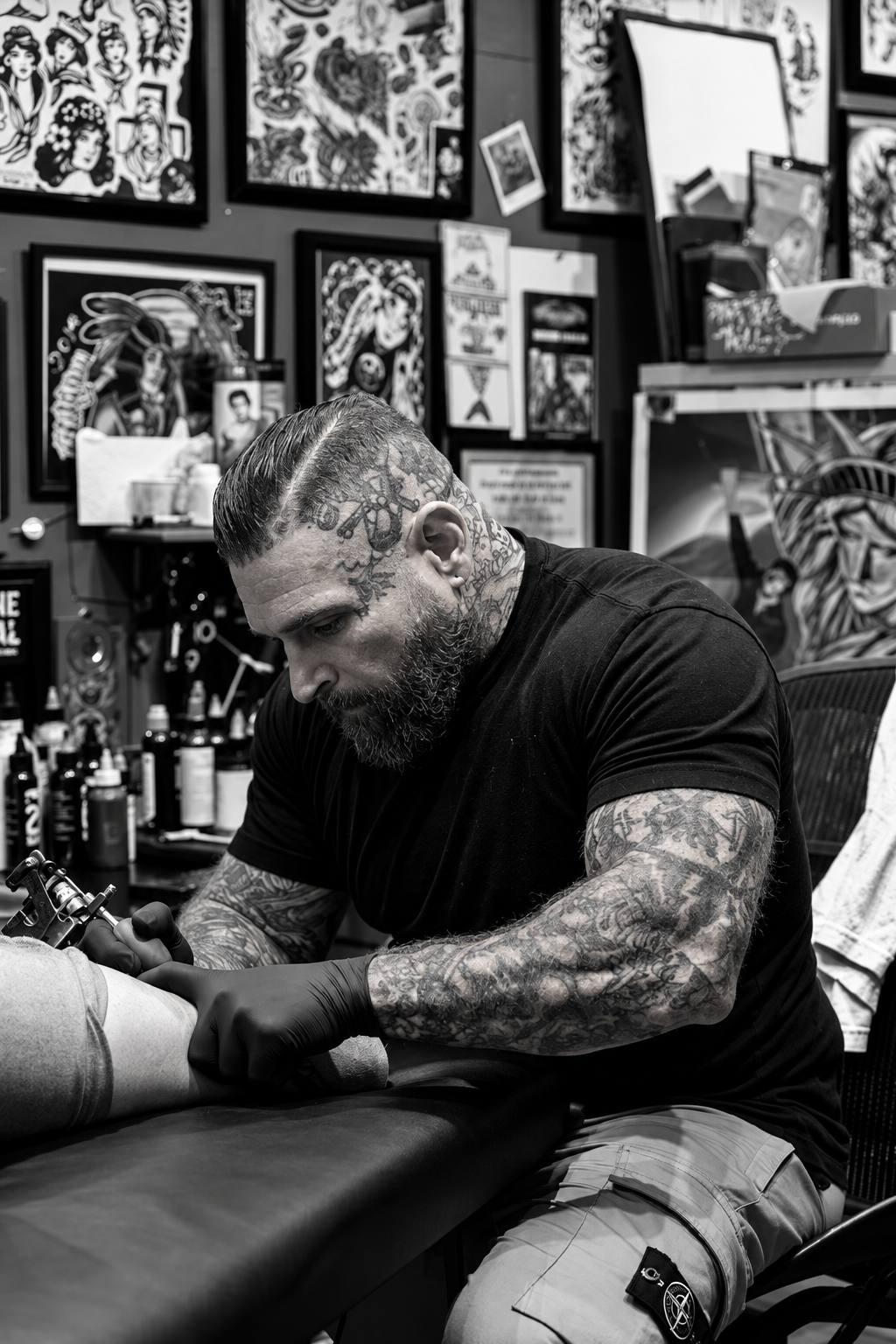 Tattoo artist at work inside Hard Times Tattoo